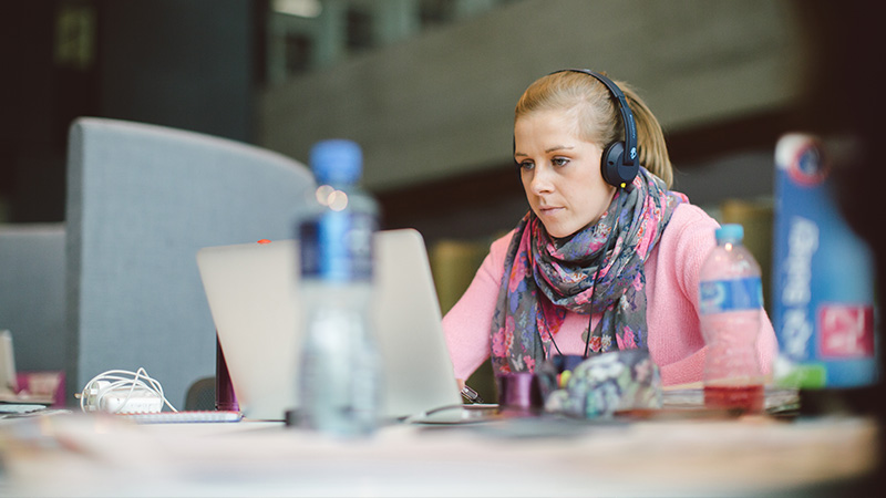 Female student studying with headphones in