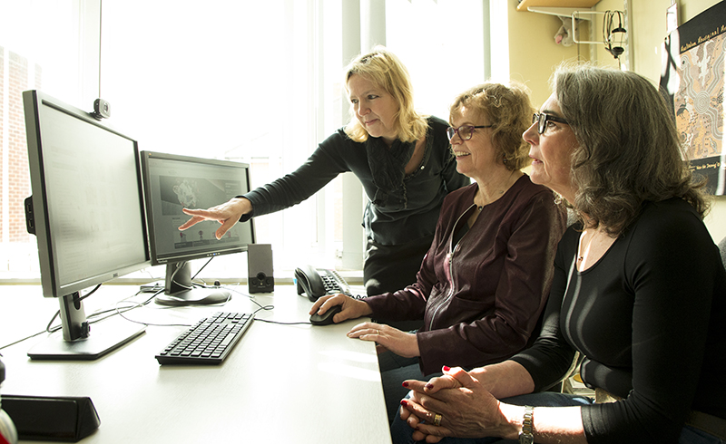 Three researchers looking at a computer