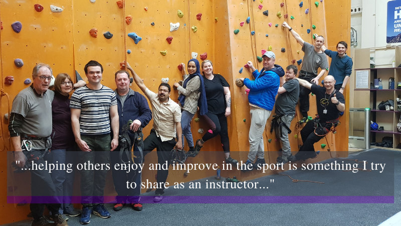 A group of people in front of a climbing wall