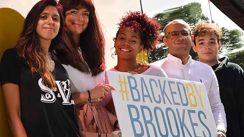 Five Brookes students holding a sign that says 'backed by Brookes'