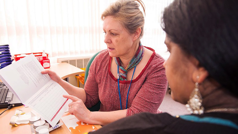 Healthcare professional showing patient an information sheet