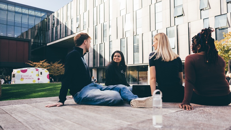 Student group outside on campus all talking to each other