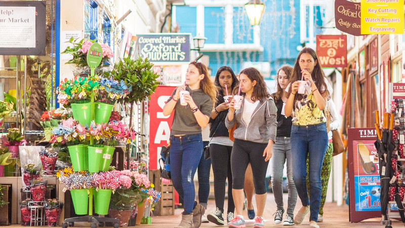 Group of female students walking around the covered market