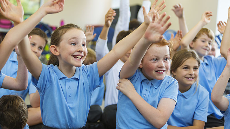 School children raising their arms