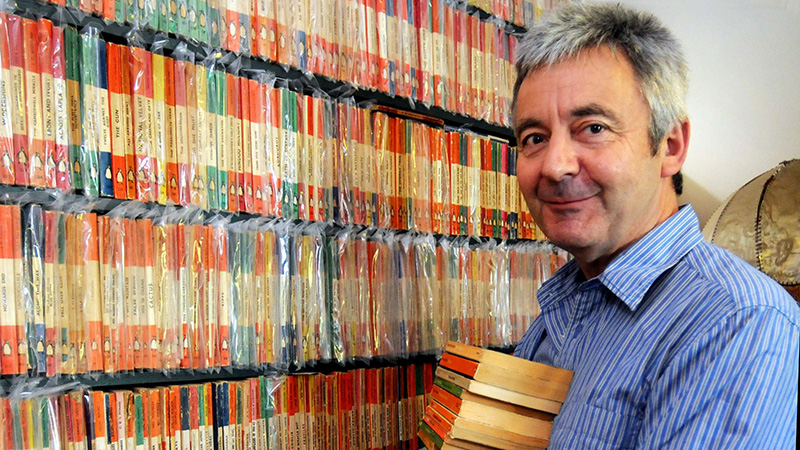 Image of Steve Hare with his Penguin book collection 