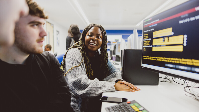 Students looking at trade markets on a computer screen