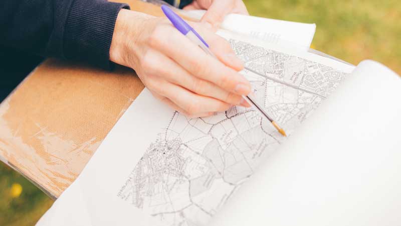 Student looking at a map of geographical features in landscape