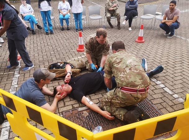 Military medics teach students emergency trauma care skills at training trial