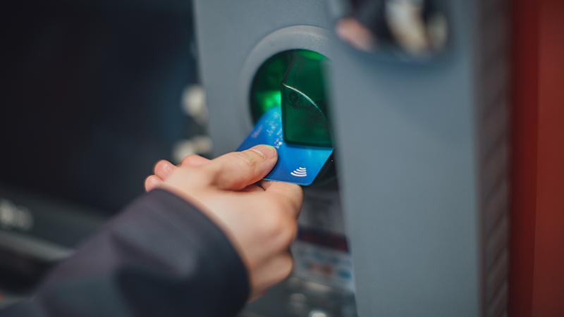 A bank card being placed into an ATM machine