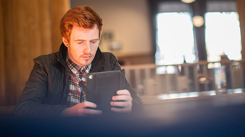 Male student looking at an IPad