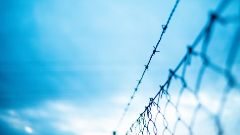 image of barbwire and blue sky