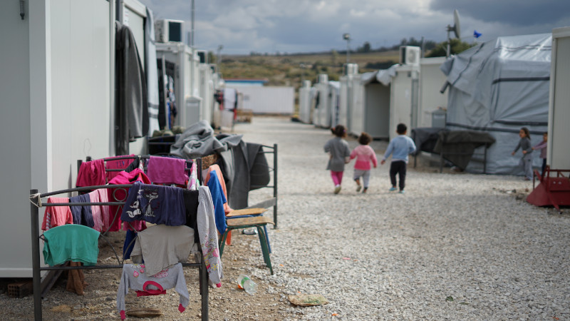 Three children pictured in a refugee camp.