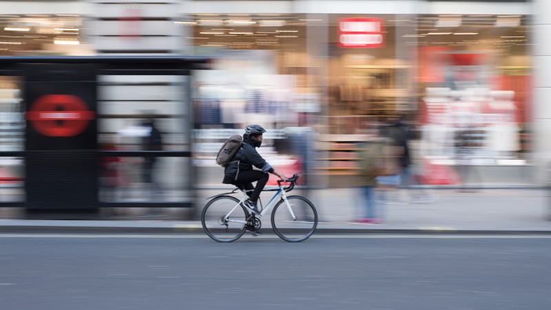 Person cycling along city street