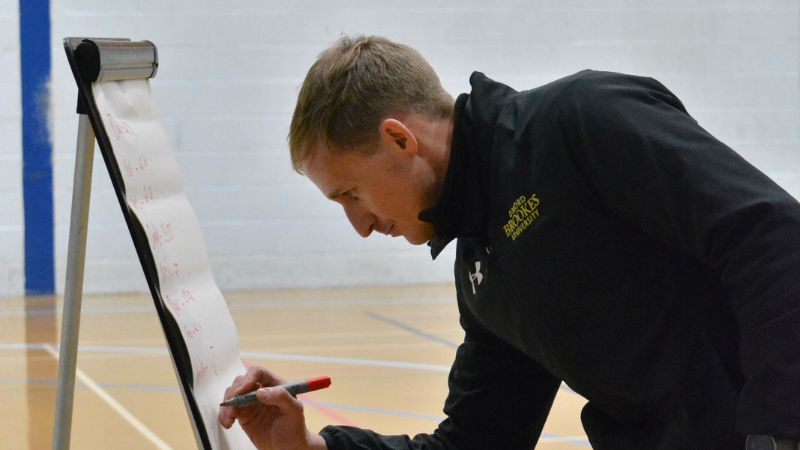 Brookes Sport staff member writing on white board