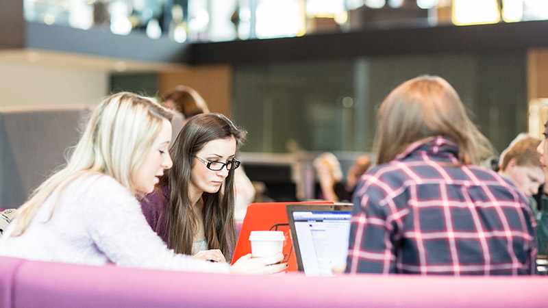 Students sitting around table in the John Henry Brookes Building