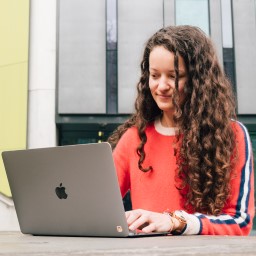 Charlotte on her laptop on campus