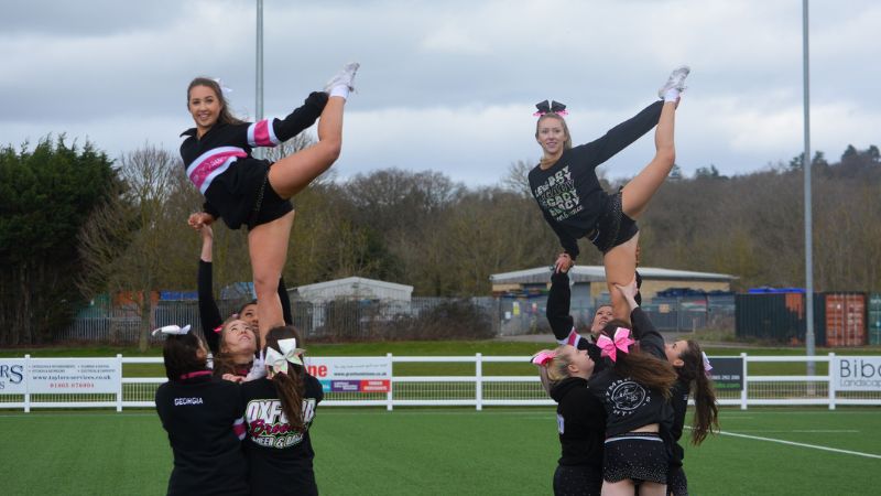 Two cheerleaders doing a stunt