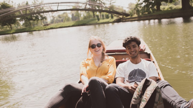 male and female students in boat on a river