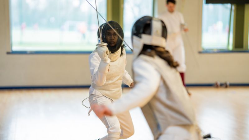 Two fencers engaging in a fencing match