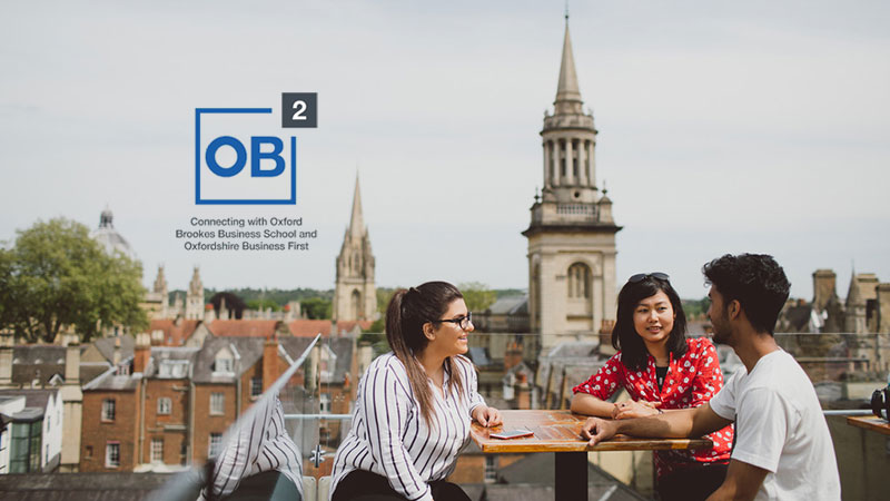 Three people sat at an Oxford rooftop restaurant
